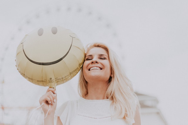Woman with a smiley-face balloon